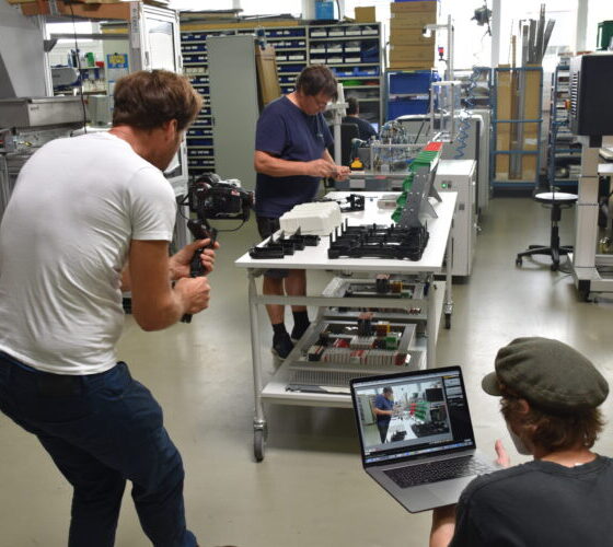 Videodreh bei k-tech Mitarbeiter monteirt Baugruppe und wird dabei gefilmt